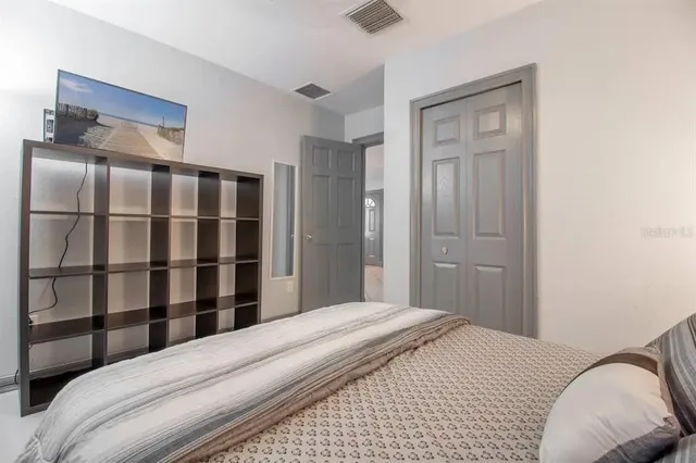 a bedroom with a bed and a painting on the wall