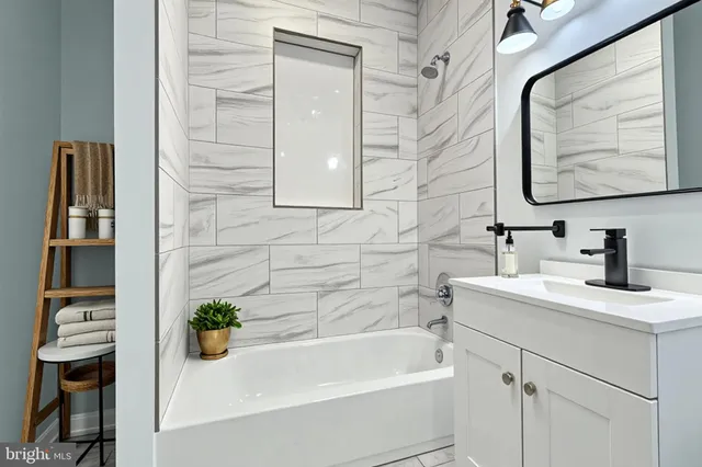 a bathroom with a tub sink and mirror