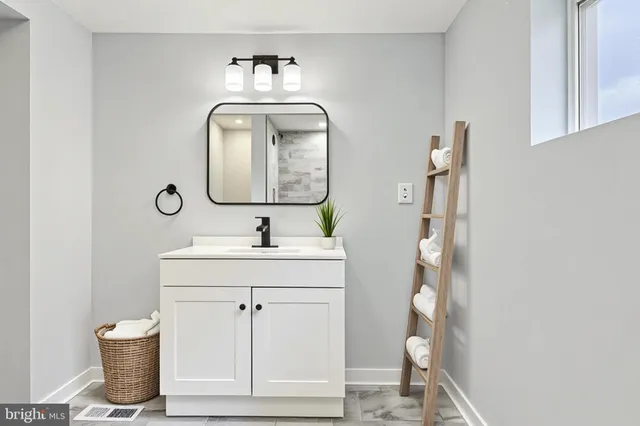 a bathroom with a sink a toilet and a mirror