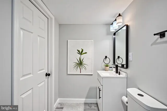 a bathroom with a toilet a sink and mirror