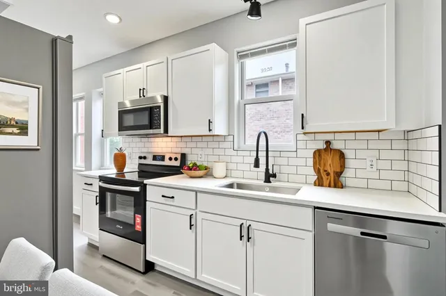 a kitchen with stainless steel appliances a sink stove and cabinets