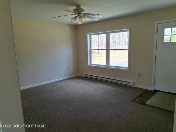 an empty room with a window and a fan