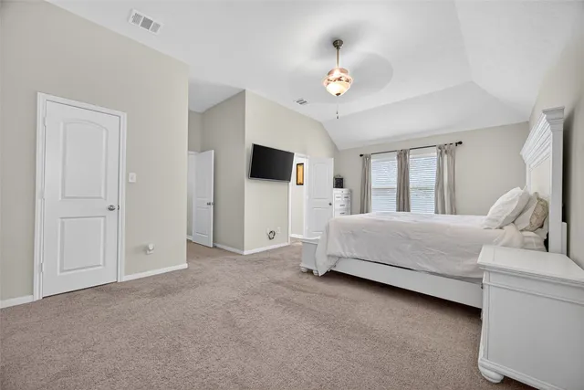 a spacious bedroom with a bed and a chandelier
