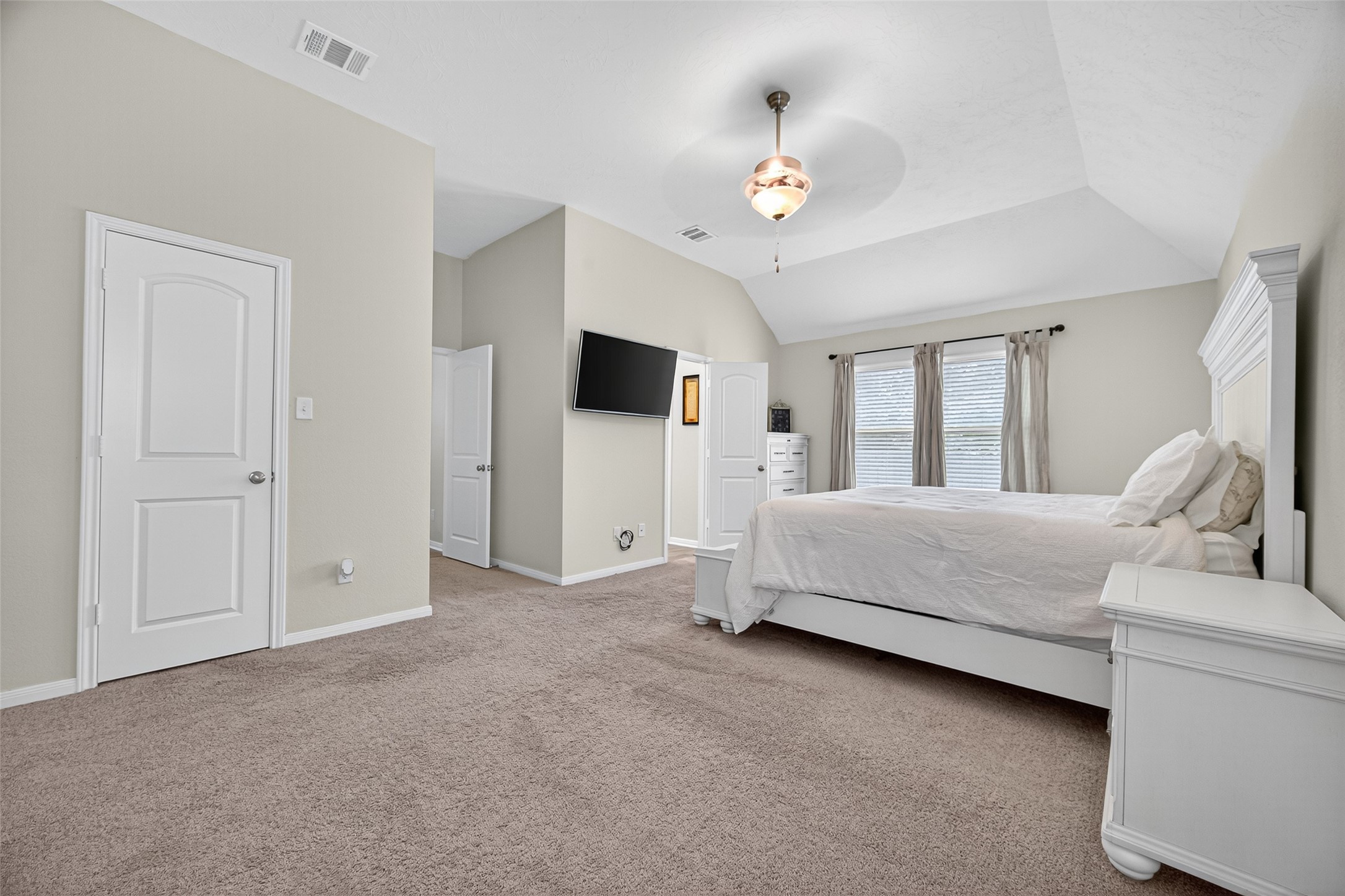 128 Red Deer Way Huntsville, TX 77320 - Photo 18 of 33 a spacious bedroom with a bed and a chandelier