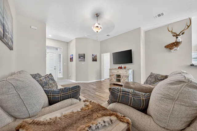 a living room with furniture and a wooden floor