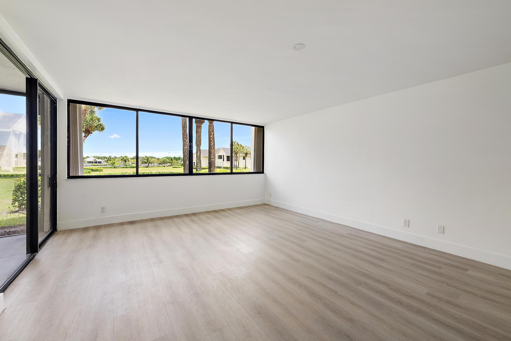 10459 Southeast Terrapin Place, Unit 101D Jupiter, FL 33469 - Photo 11 of 49 wooden floor in an empty room with a window