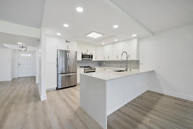 a kitchen with stainless steel appliances a refrigerator sink and cabinets