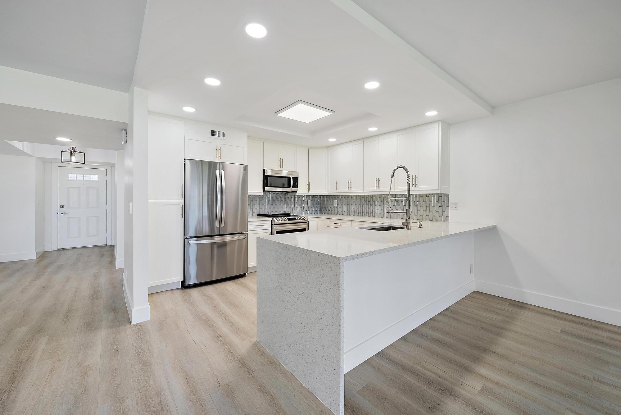 10459 Southeast Terrapin Place, Unit 101D Jupiter, FL 33469 - Photo 12 of 49 a kitchen with stainless steel appliances a refrigerator sink and cabinets