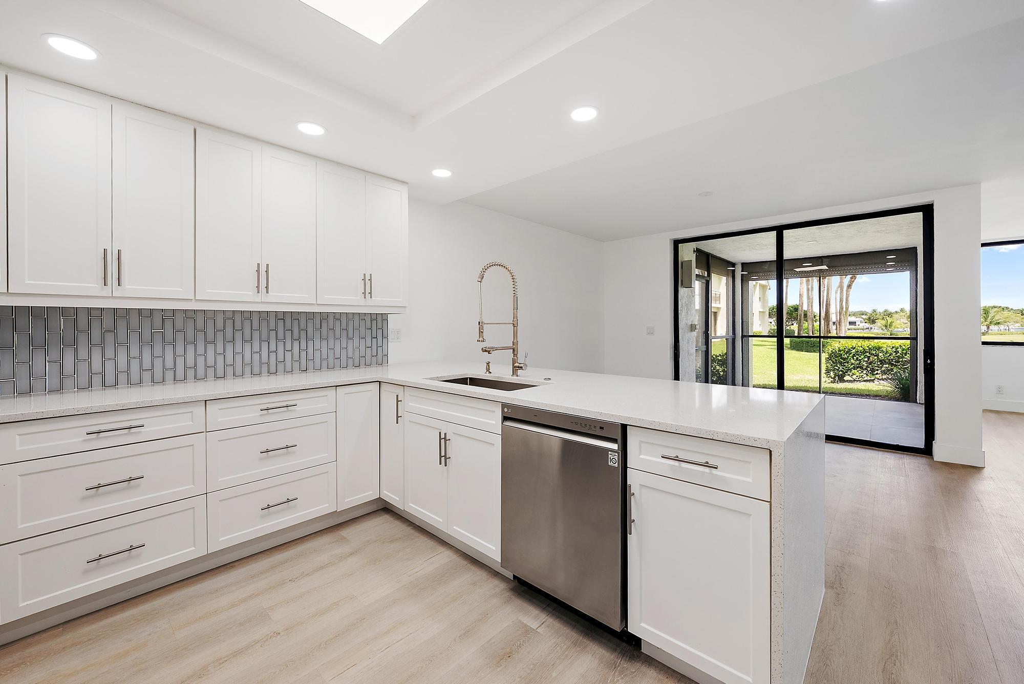 10459 Southeast Terrapin Place, Unit 101D Jupiter, FL 33469 - Photo 15 of 49 a kitchen with granite countertop white cabinets and white appliances