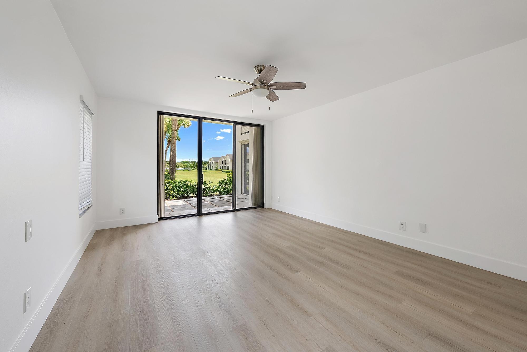 10459 Southeast Terrapin Place, Unit 101D Jupiter, FL 33469 - Photo 18 of 49 an empty room with wooden floor and windows