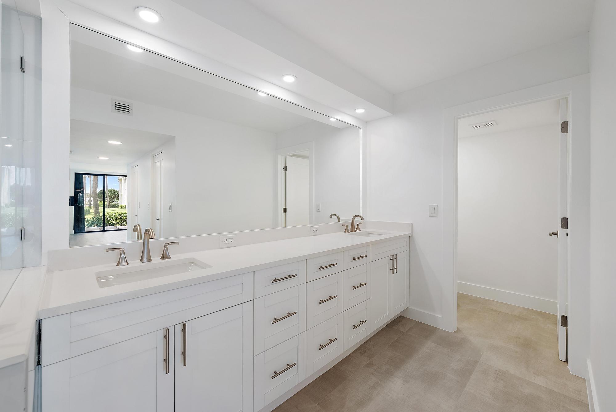10459 Southeast Terrapin Place, Unit 101D Jupiter, FL 33469 - Photo 19 of 49 a bathroom with double sink and a mirror