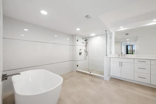 a large white bathroom with a bathtub and a sink