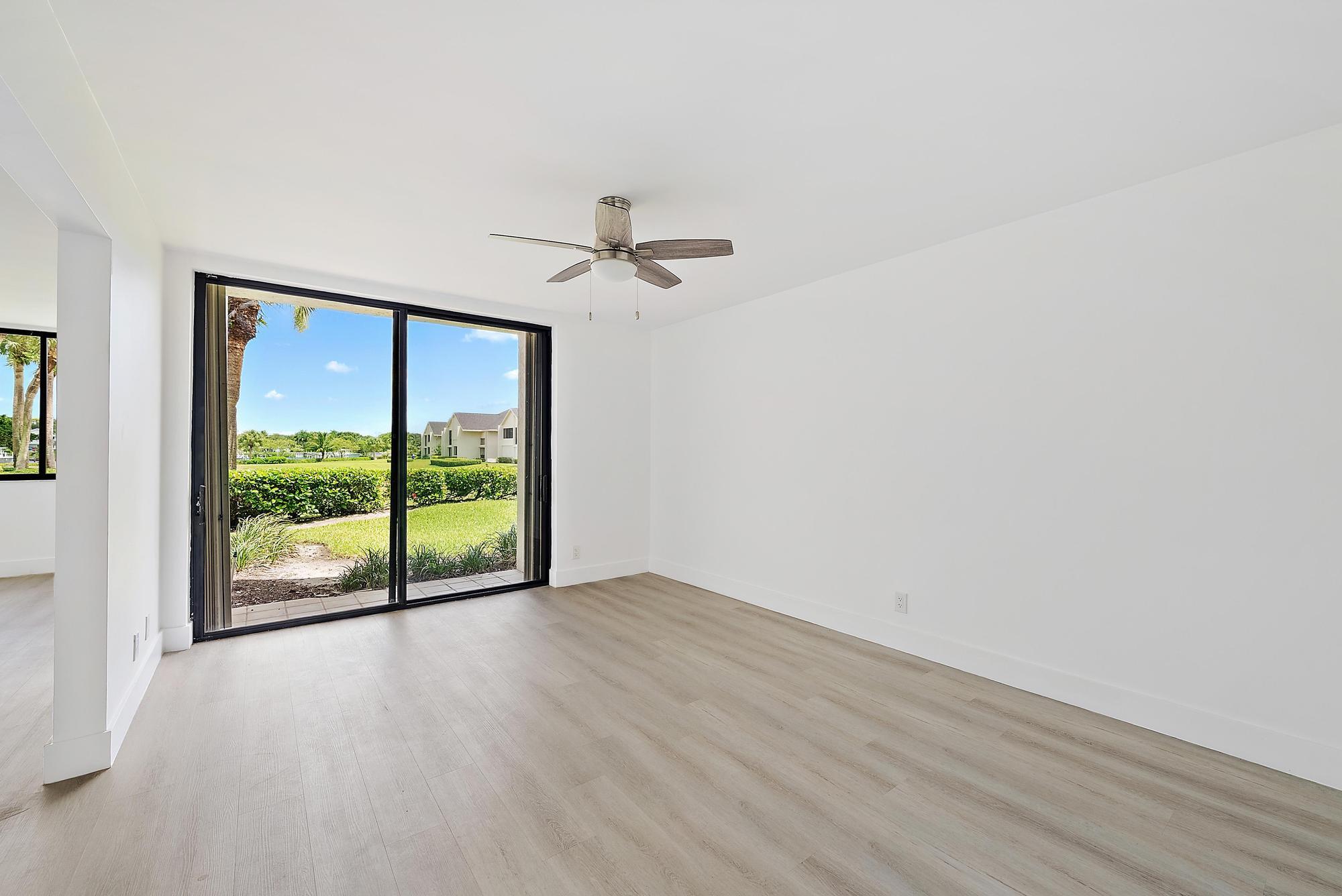 10459 Southeast Terrapin Place, Unit 101D Jupiter, FL 33469 - Photo 23 of 49 a view of an empty room with a window and wooden floor