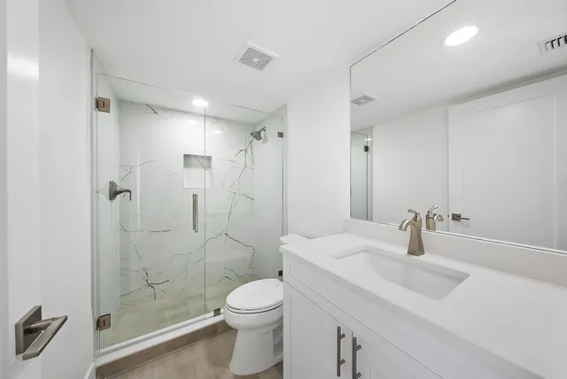 a bathroom with a sink toilet a mirror and shower