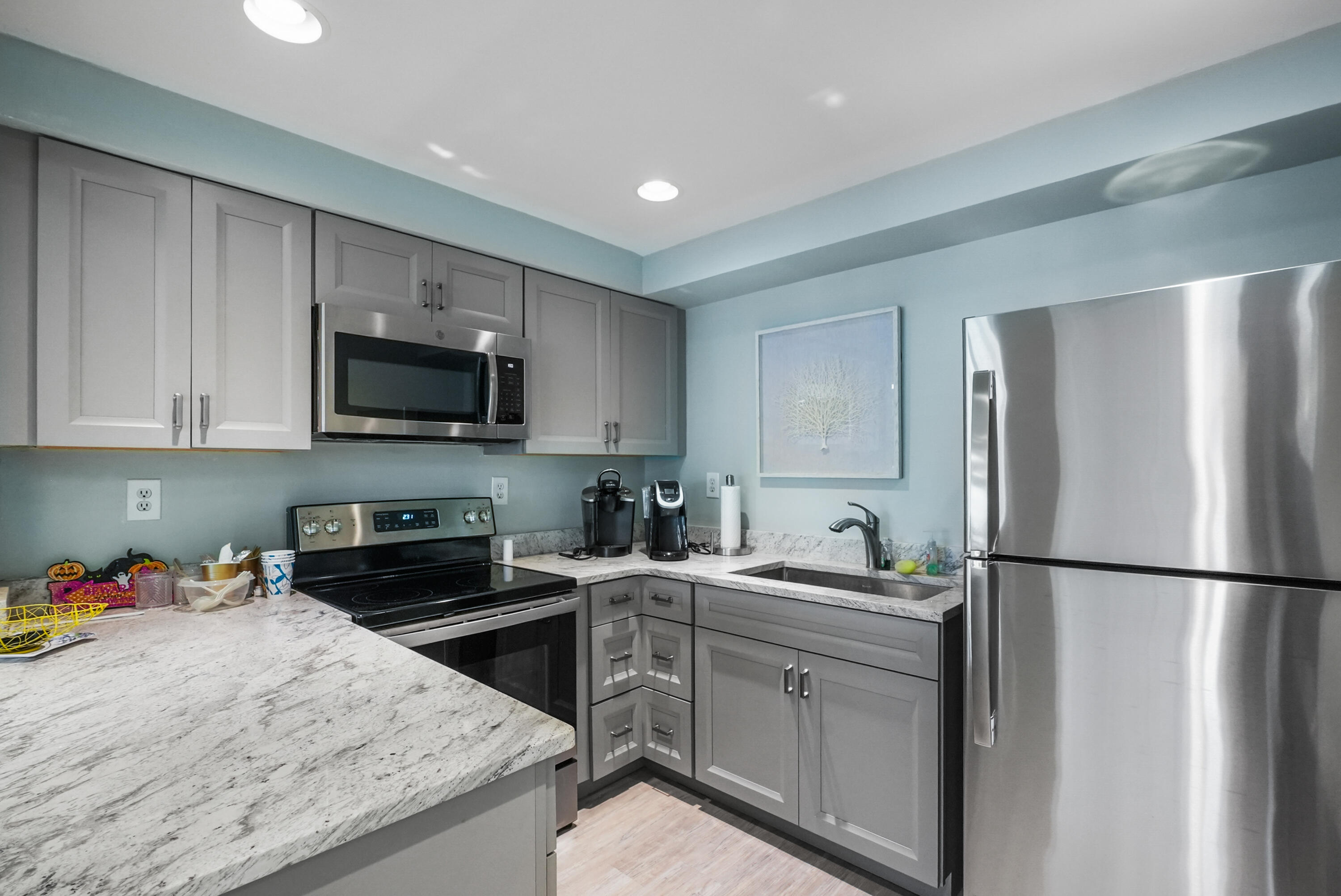 10459 Southeast Terrapin Place, Unit 101D Jupiter, FL 33469 - Photo 41 of 49 a kitchen with a sink a refrigerator and a stove top oven