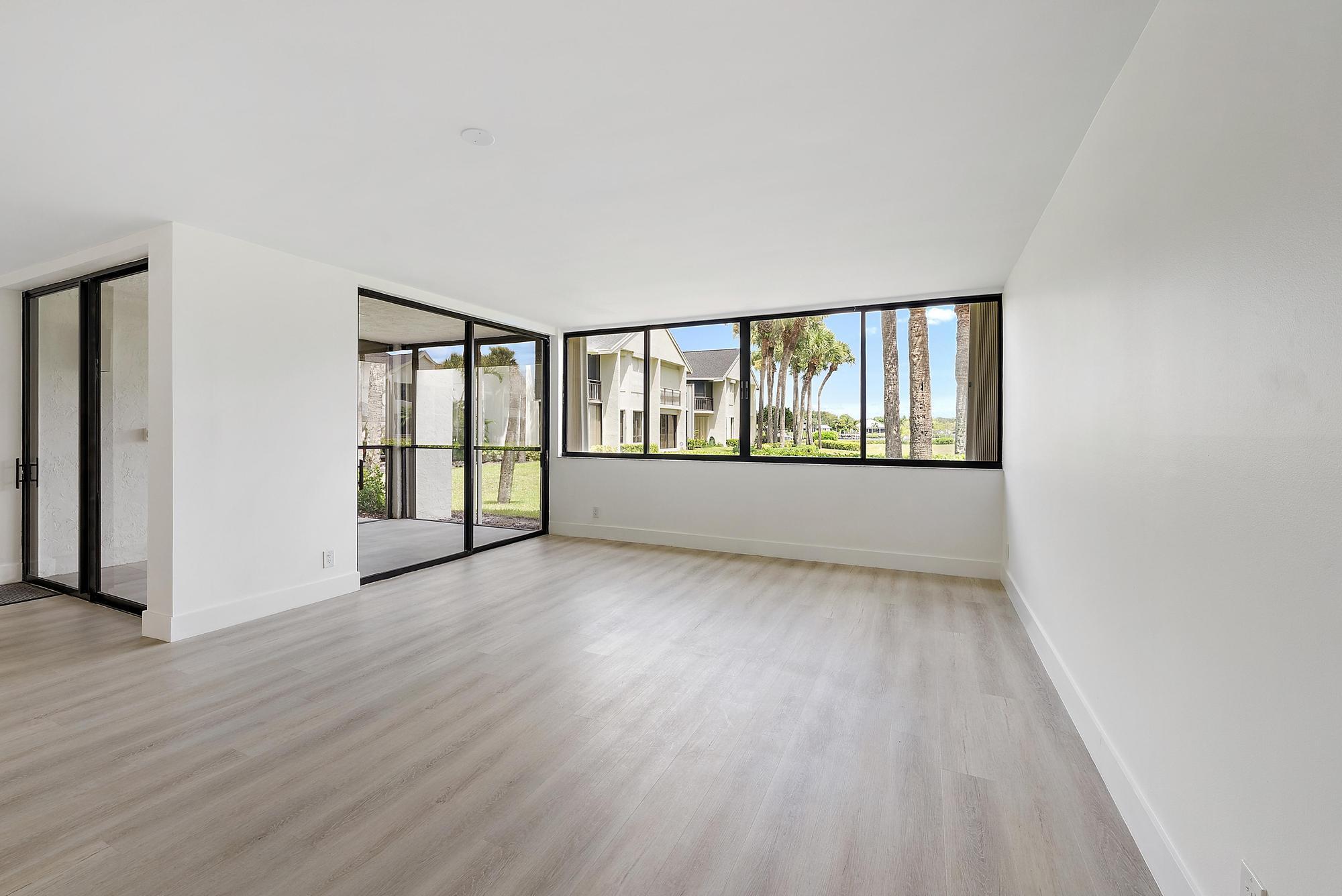 10459 Southeast Terrapin Place, Unit 101D Jupiter, FL 33469 - Photo 7 of 49 wooden floor in an empty room with a window