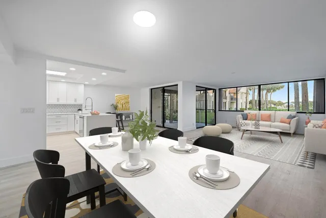 a dining room with furniture a large window and a view of kitchen