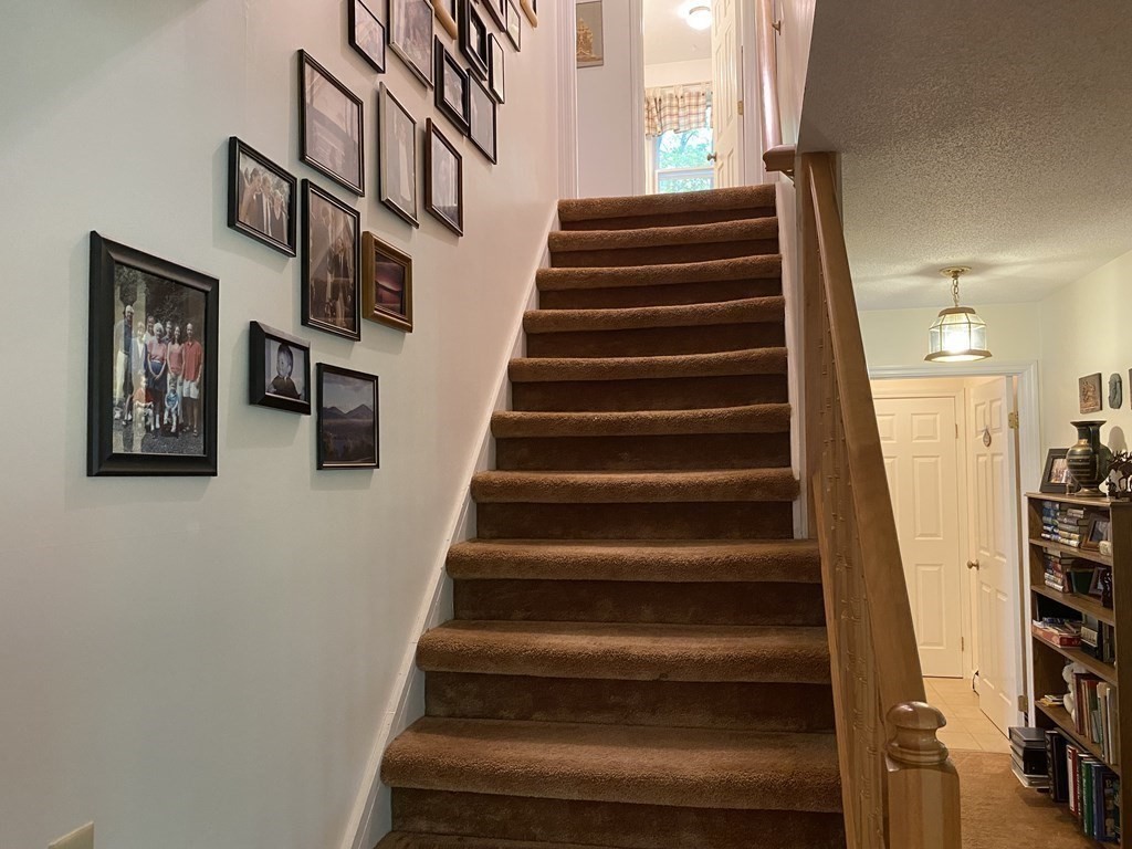 76 Main Road Gill, MA 01354 - Photo 24 of 36 a view of staircase with lots of frames on wall and a window