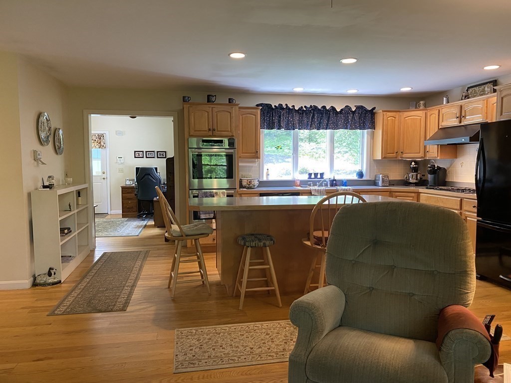 76 Main Road Gill, MA 01354 - Photo 6 of 36 a living room with stainless steel appliances granite countertop furniture a fireplace a flat screen tv and a large window