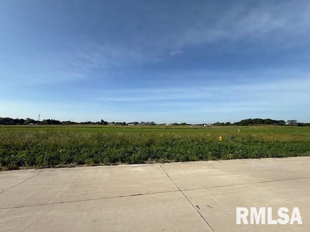 a view of a green field with an ocean