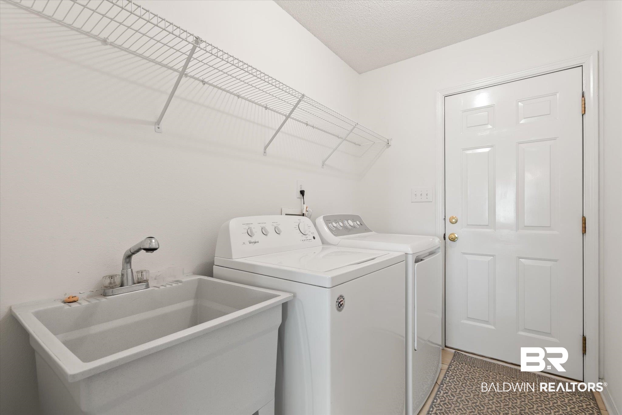 12520 Hunters Chase Foley, AL 36535 - Photo 31 of 32 Laundry room with laundry area, light tile patterned flooring, a sink, a textured ceiling, and washer and clothes dryer