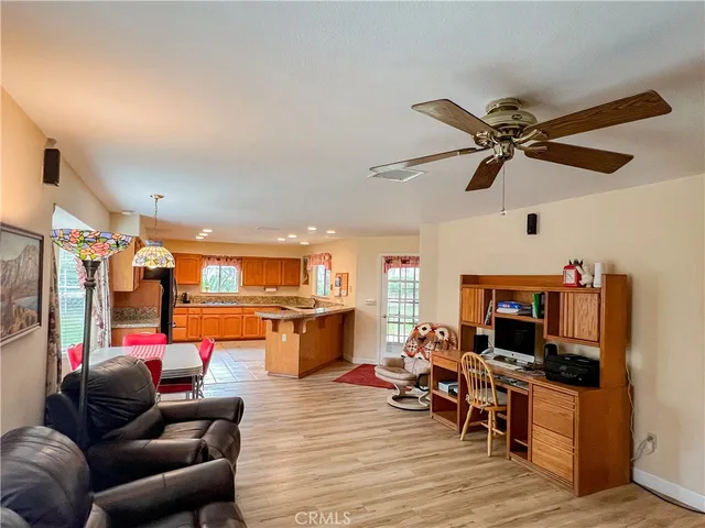 a view of a dining room and livingroom with furniture wooden floor a chandelier