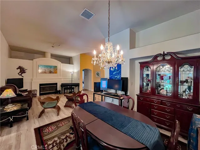 a view of a dining room with furniture a chandelier and wooden floor