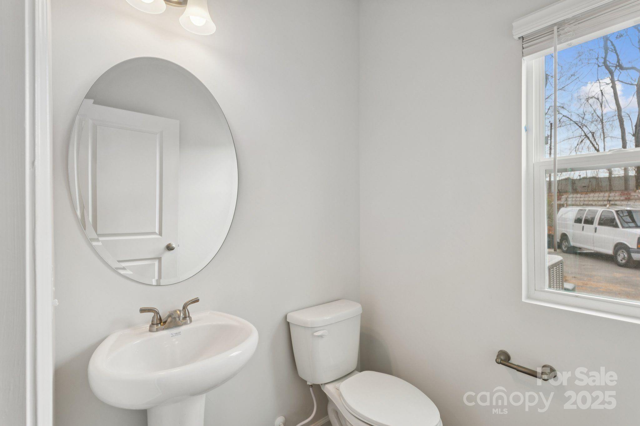 4742 Lakeview Road, Unit 17 Charlotte, NC 28216 - Photo 15 of 27 a bathroom with a toilet sink and mirror