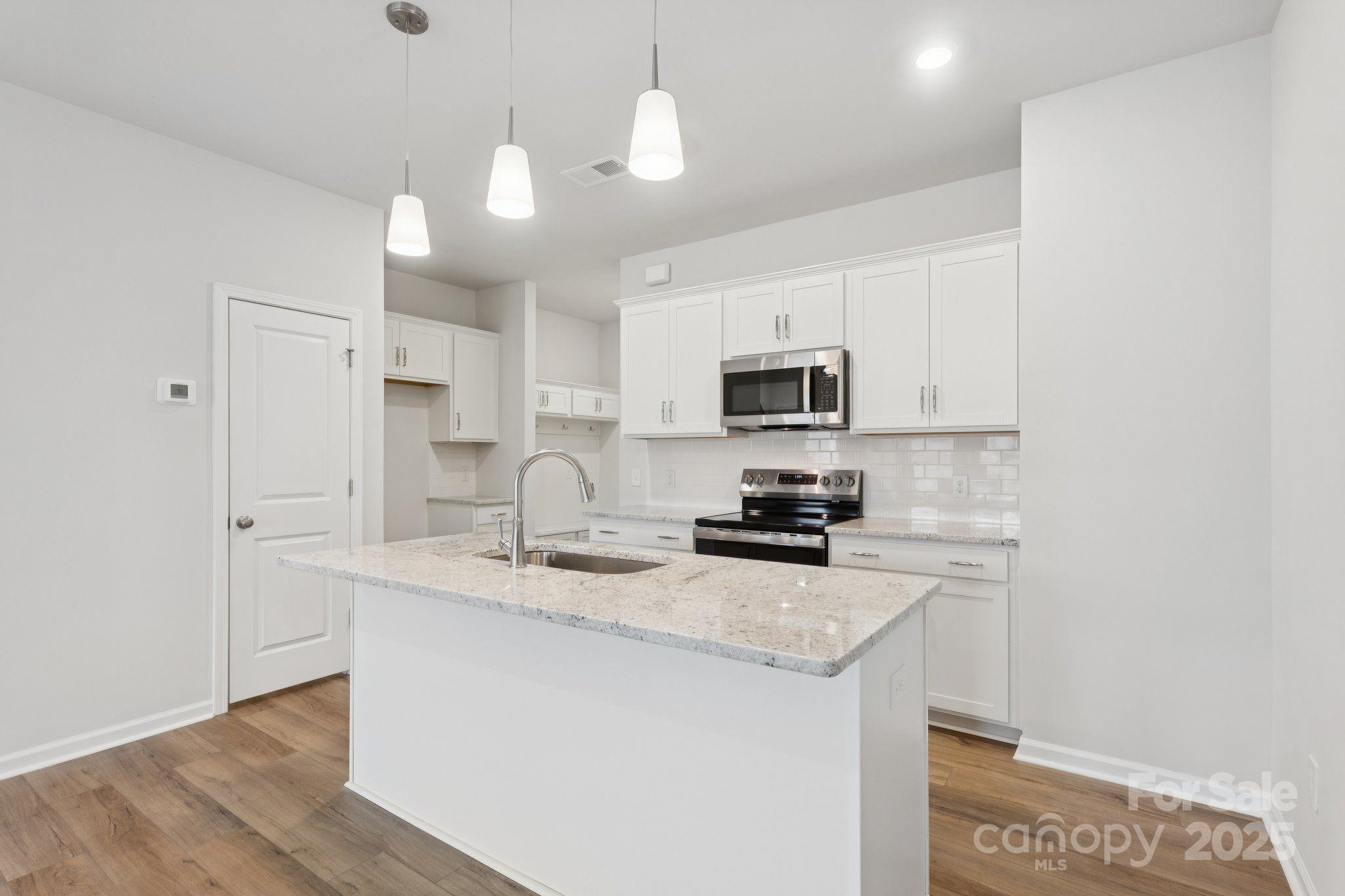 4742 Lakeview Road, Unit 17 Charlotte, NC 28216 - Photo 8 of 27 a kitchen with a sink a stove a microwave and cabinets