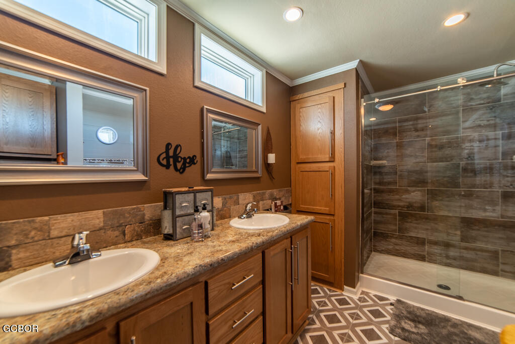 551 Summit Trail, Unit 199 Granby, CO 80446 - Photo 16 of 34 a bathroom with a granite countertop sink a mirror and shower