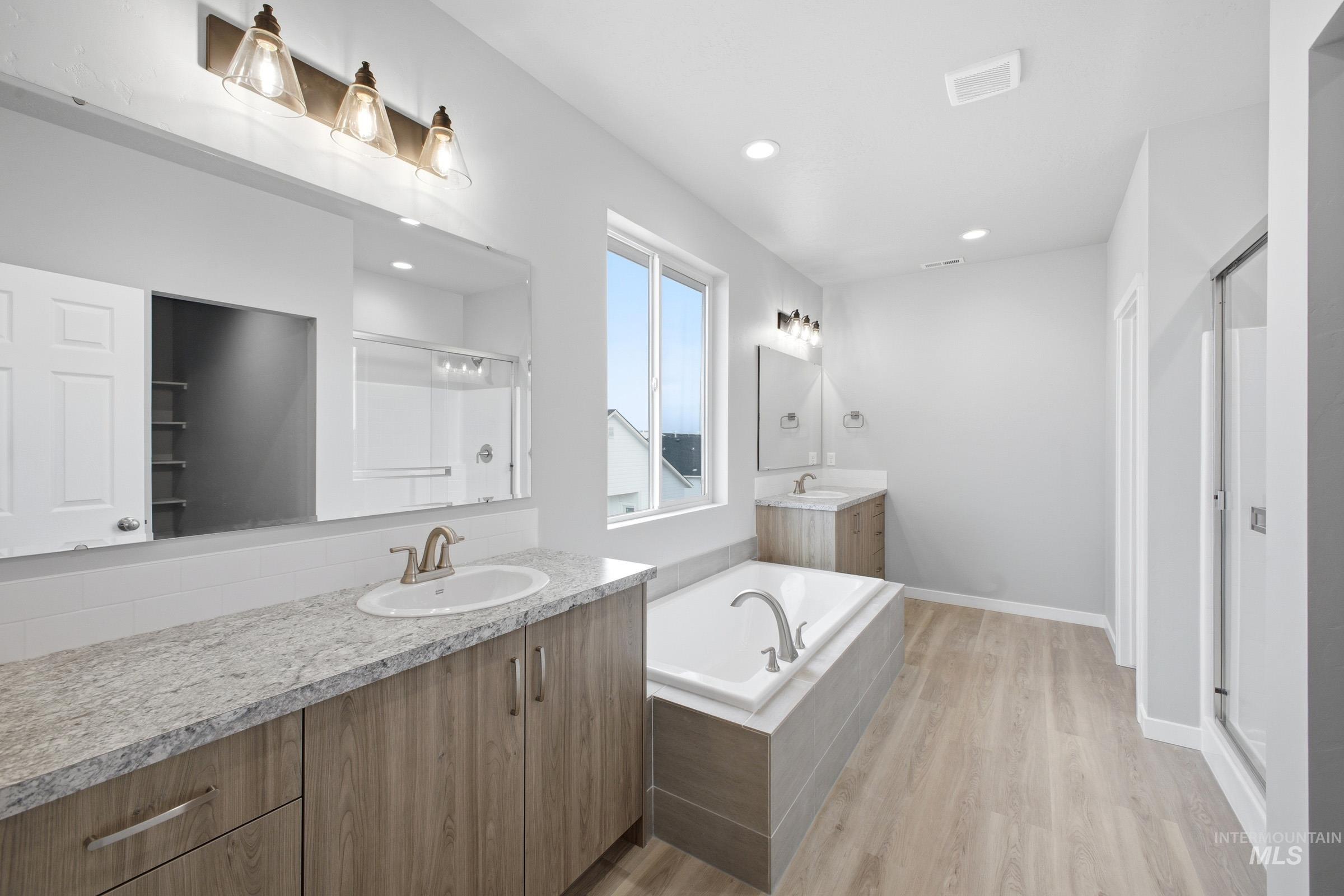 13672 Redway Court Caldwell, ID 83607 - Photo 30 of 34 Bathroom featuring two vanities, a shower stall, a garden tub, light wood finished floors, and recessed lighting