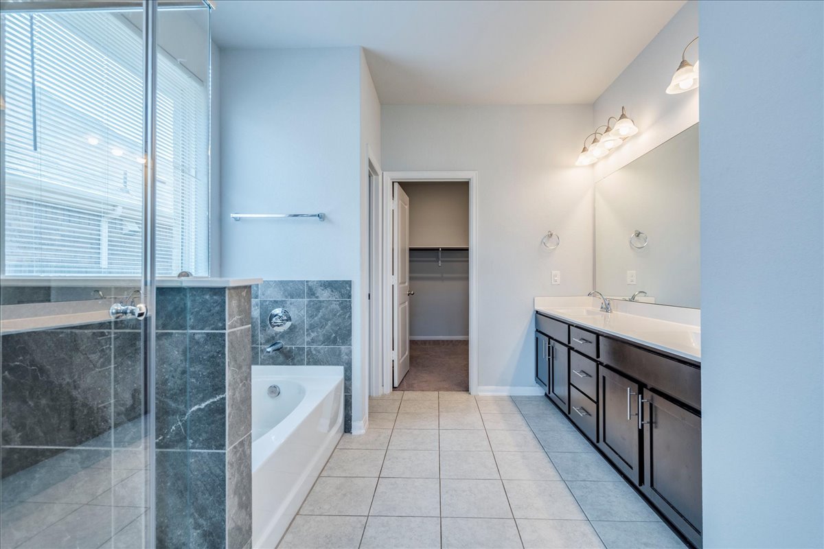 275 Cherrystone Loop Buda, TX 78610 - Photo 19 of 33 Primary bathroom featuring double sinks, walk-in shower and soaking tub.