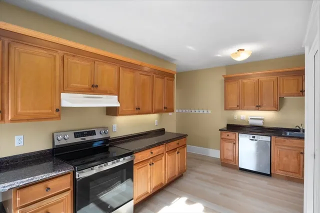 a kitchen with stainless steel appliances granite countertop a refrigerator and a stove top oven