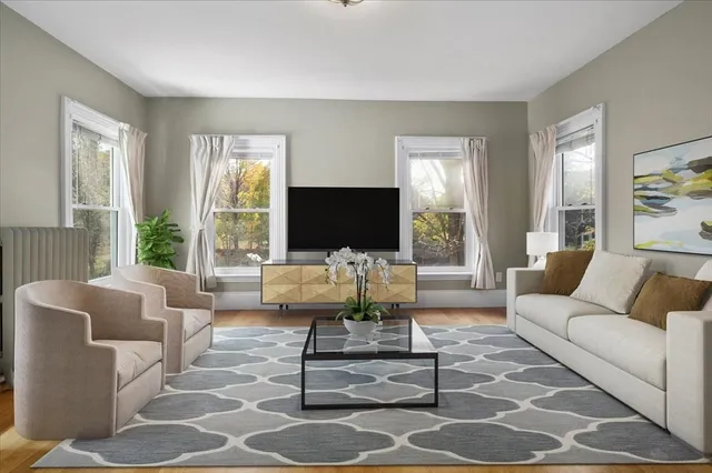 a living room with furniture a flat screen tv and a large window