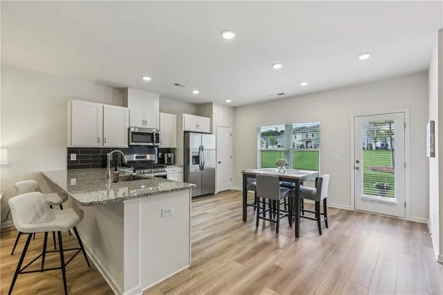 a kitchen with a table chairs microwave and cabinets