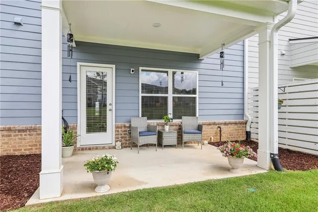 a patio with table and chairs and potted plants