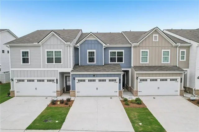 an aerial view of residential houses with outdoor space and parking