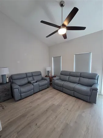 a living room with furniture and a ceiling fan