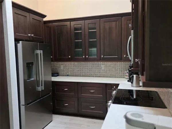 a kitchen with a sink a refrigerator and cabinets