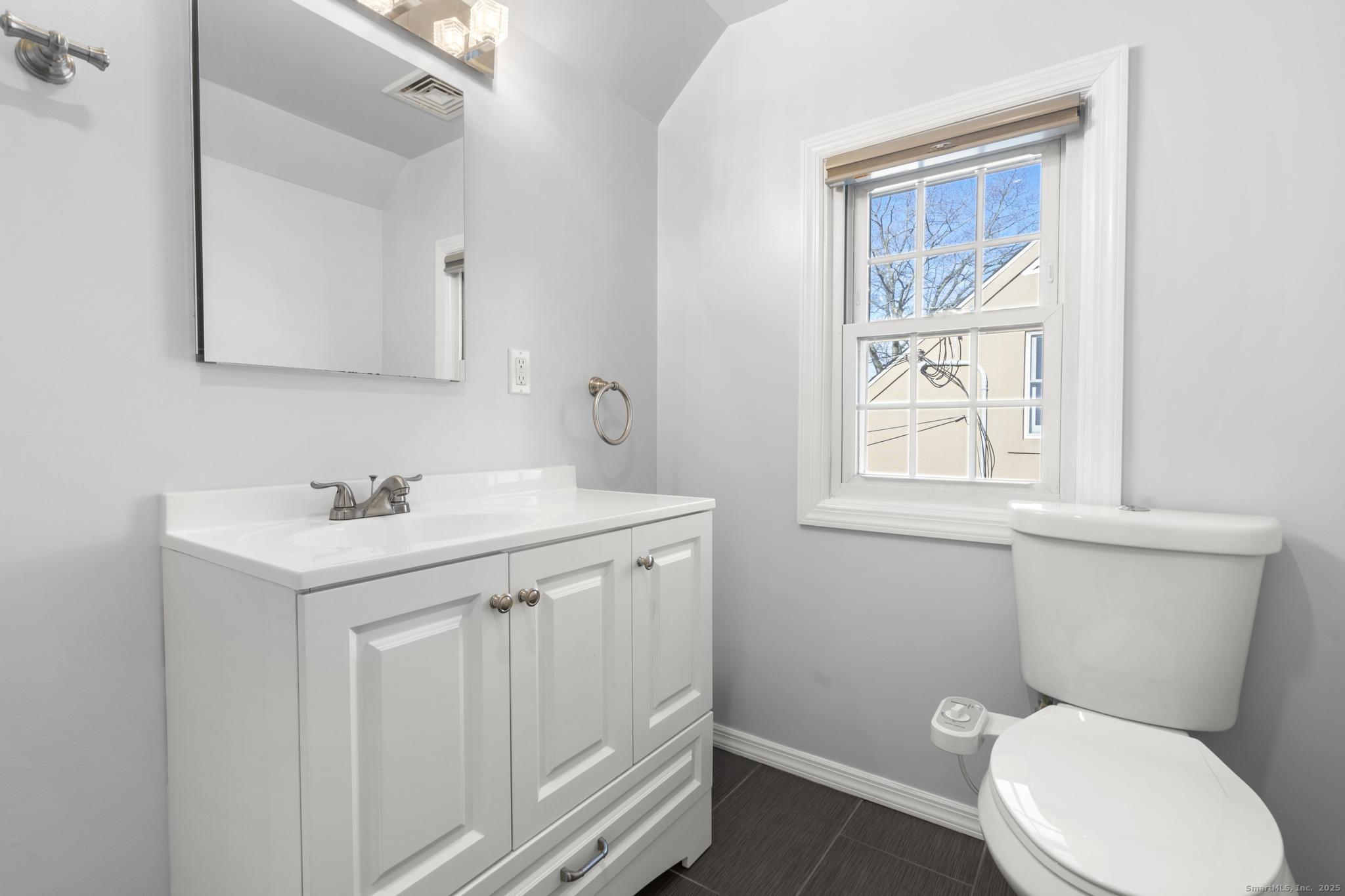 16 Silk Street Norwalk, CT 06850 - Photo 12 of 34 a bathroom with a toilet a sink a vanity and mirror