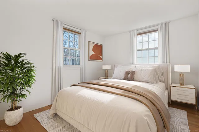 a bedroom with a large bed and a potted plant