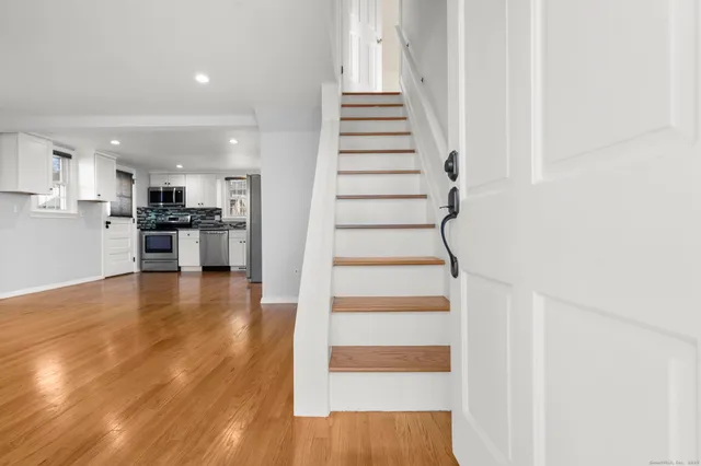 a view of entryway and kitchen with wooden floor