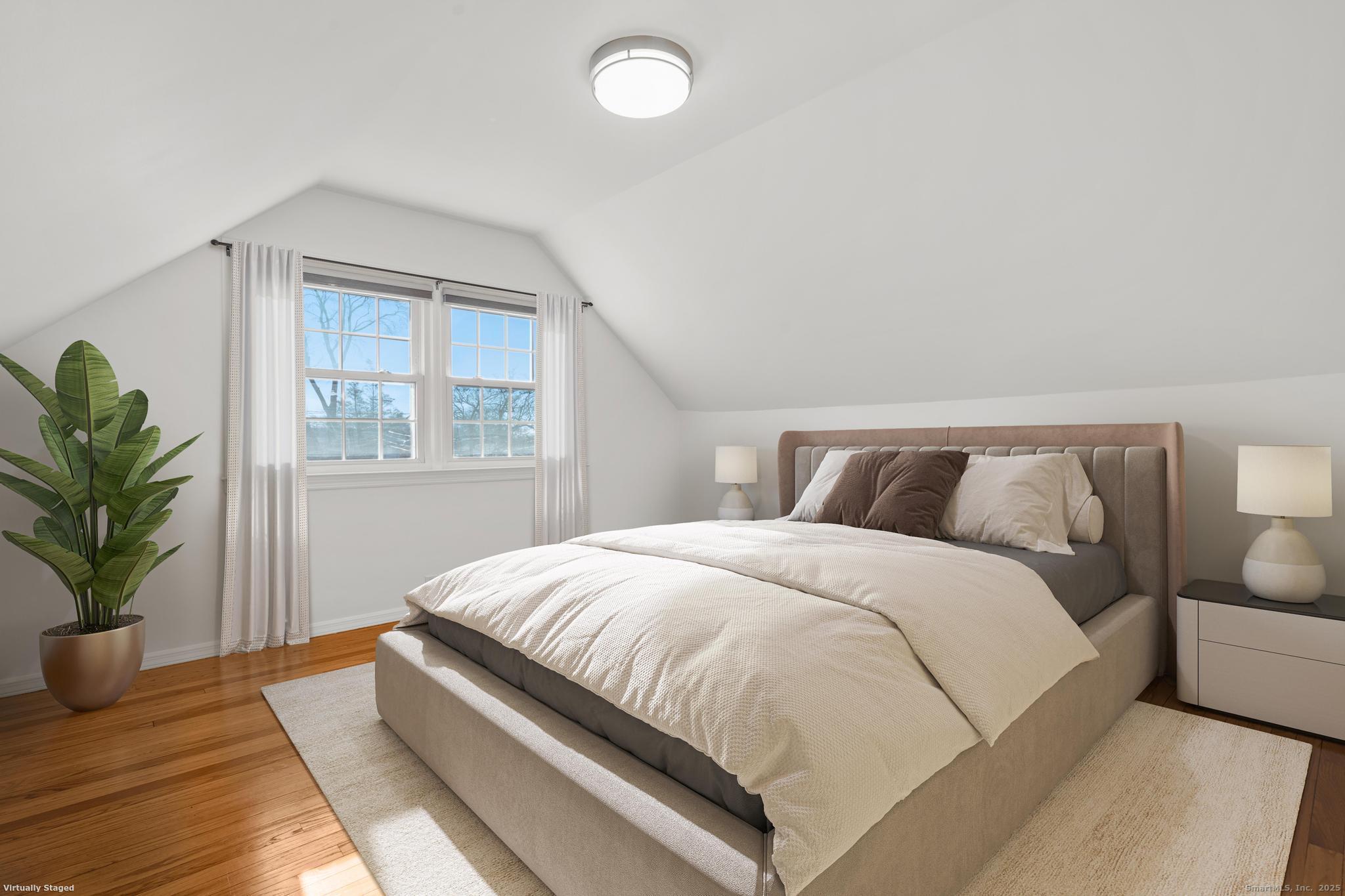 16 Silk Street Norwalk, CT 06850 - Photo 10 of 34 a bedroom with a large bed and potted plant with wooden floor