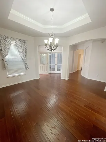 a view of a room with wooden floor chandelier and a window