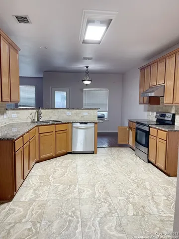 a kitchen with stainless steel appliances granite countertop a stove sink and cabinets