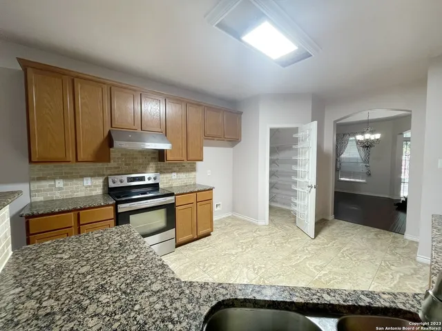 a kitchen with granite countertop a stove and cabinets