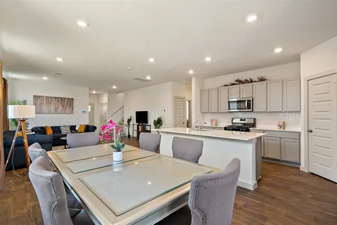 a large kitchen with sink a refrigerator a stove a dining table and chairs