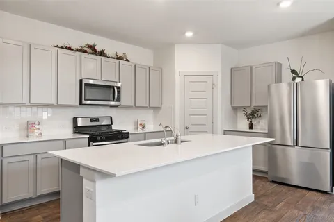 a kitchen with kitchen island a sink appliances and cabinets