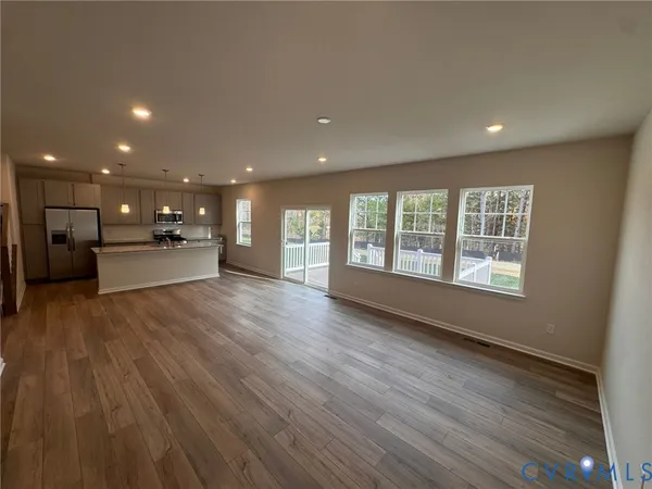 a kitchen with kitchen island granite countertop a sink refrigerator and microwave