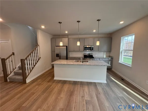a view of a big room with wooden floor and windows